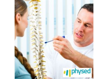 Fisioterapeuta explicando sobre anatomía vertebral a una paciente en Clínica Physed.